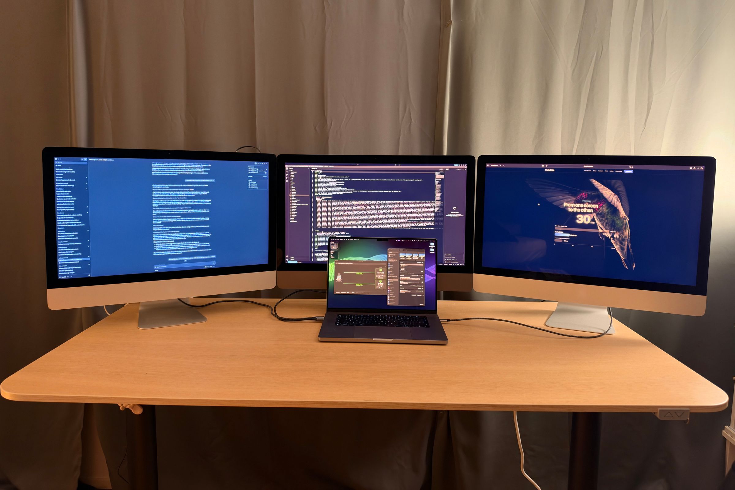 Three iMacs as displays for a MacBook Pro: documents on the left, a code editor in the middle and a website on the right, with the MacBook in front.