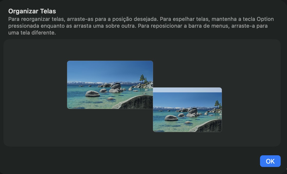 A folha Organizar Telas nos Ajustes do Sistema: dois retângulos de tela lado a lado, o iMac maior à esquerda e o MacBook à direita, com um botão OK.